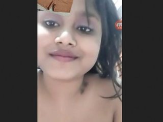 A stunning young woman showcases her large breasts