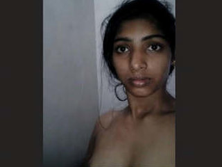 A seductive woman with large breasts performs a striptease in the restroom