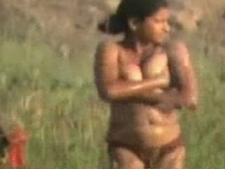 Naked Indian teen girl bathing in the field